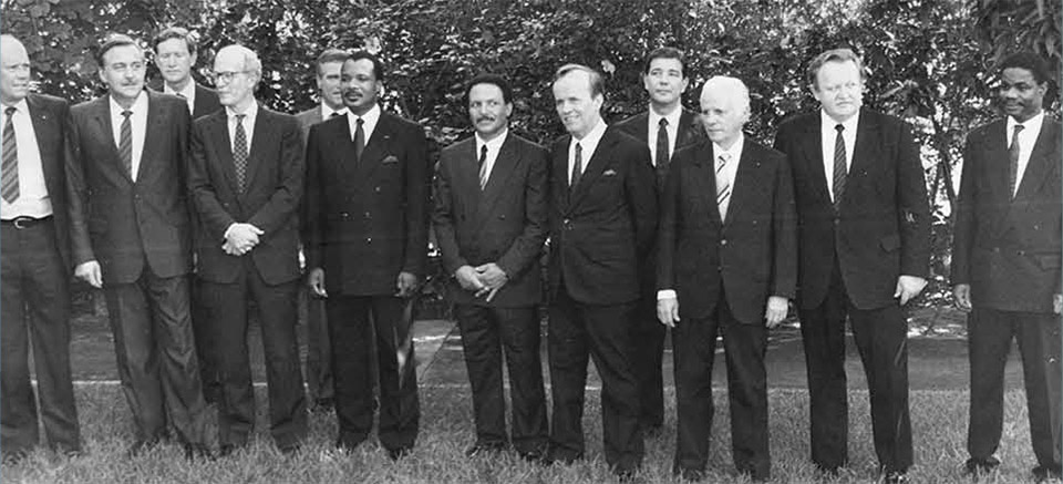 At the Brazzaville Protocol negotiations are South African Defence Minister Magnus Malan, Foreign Minister Pik Botha, US Assistant Secretary of State for African Affairs Chester Crocker, President Denis Sassou Nguesso, French secret agent Jean-Yves Ollivier and (2nd from right) Finland's Martti Ahtisaari.[1]