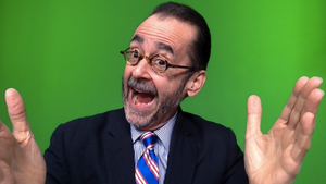 Lionel with open mouth smile in front of green screen with open welcoming large hands close to camera - a screen grab @5m50s from his YouTube video QhHJXVSNHzM - Lionel Nation 'Lionel on Radio New Zealand Diagnosing Hillary Clinton' (2016-10-05)